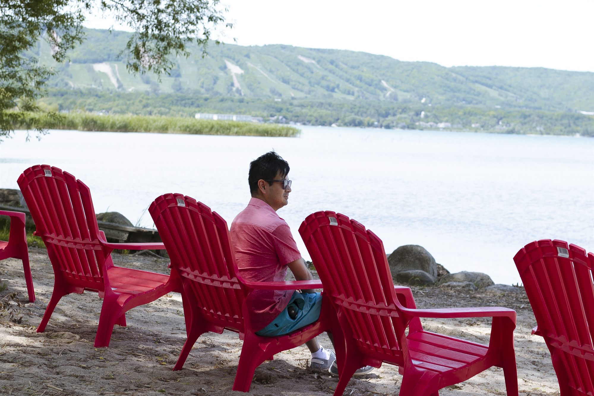 Muskoka chairs on the private sand beach looking across Georgian Bay to the Blue Mountain escarpment