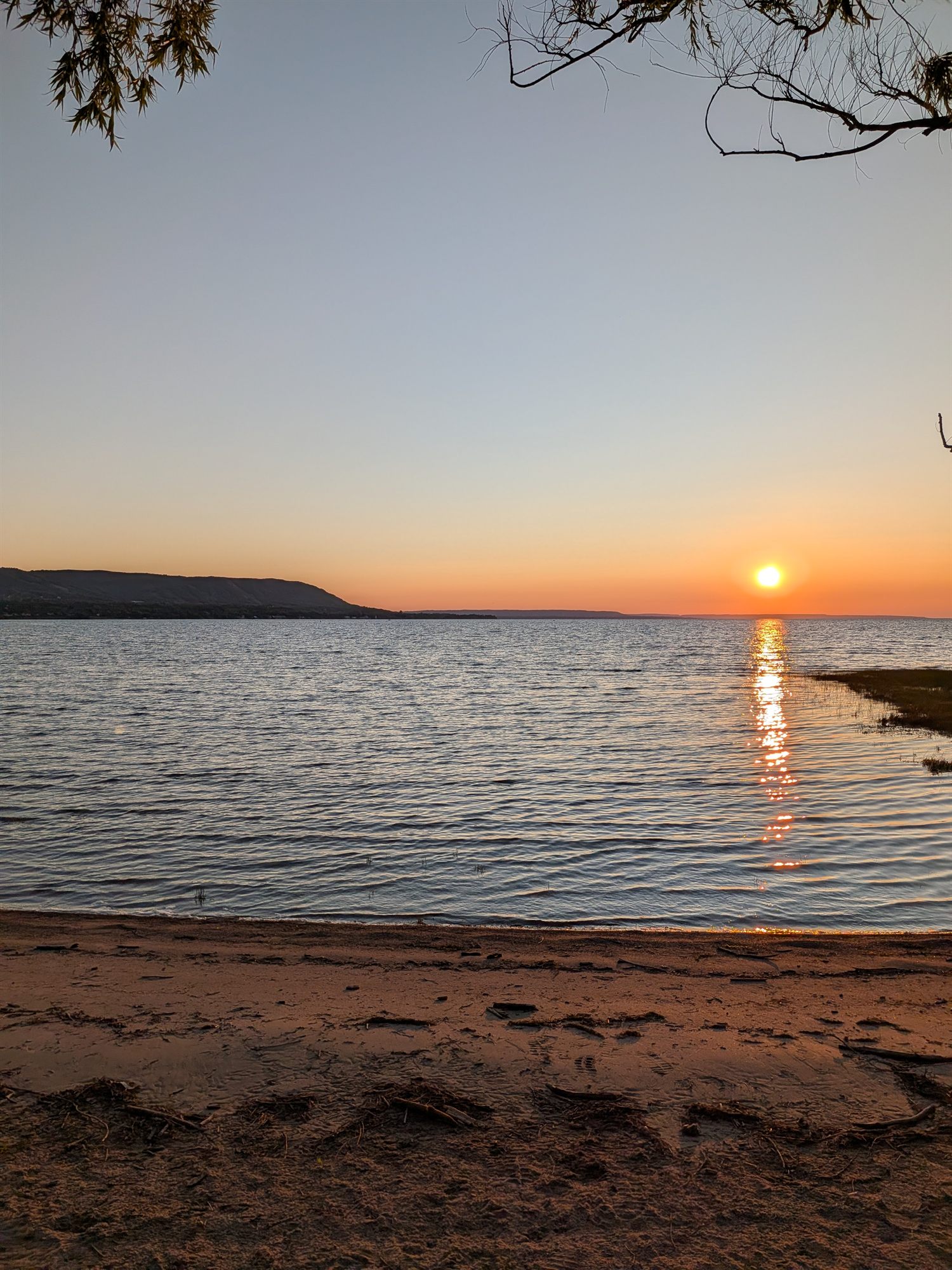Footprints in the sand as the sun sets over Georgian Bay