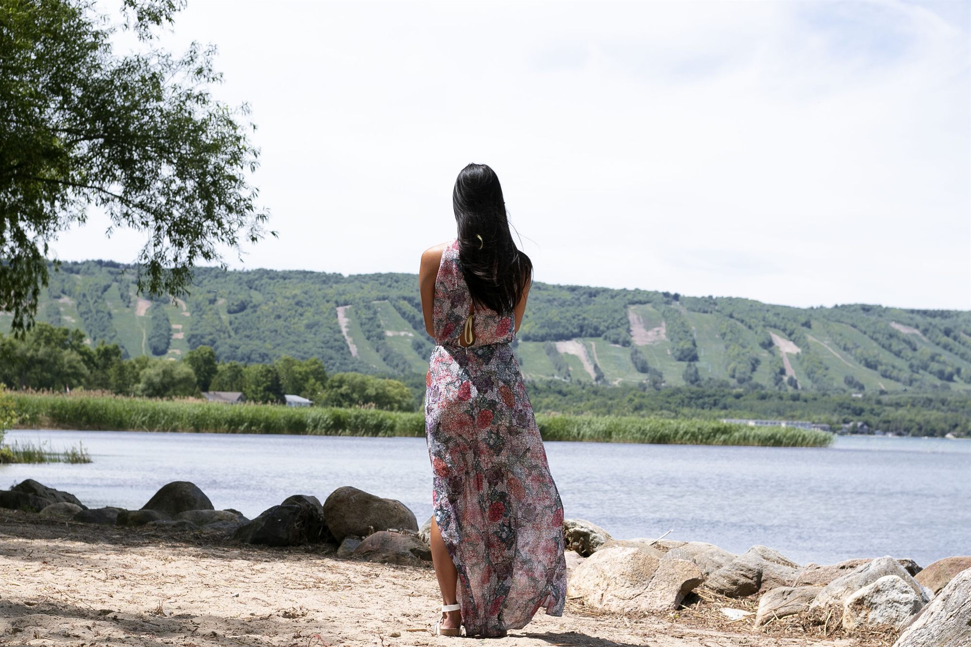 A guest on the private beach looking across Georgian Bay toward the summer ski runs of Blue Mountain